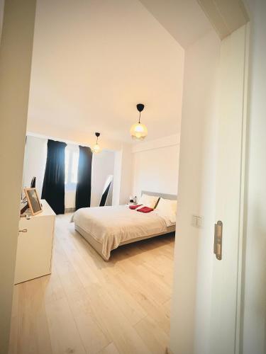 a bedroom with a bed and a wooden floor at Airport Gardens Loft in Otopeni
