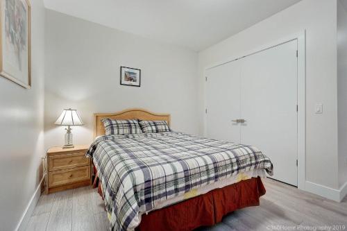 a bedroom with a bed and a night stand with a lamp at D Peaceful Suite in West Vancouver