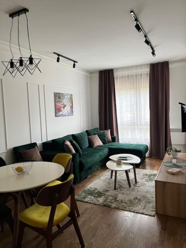 a living room with a green couch and tables at Apartman Natalijina Ramonda in Zlatibor