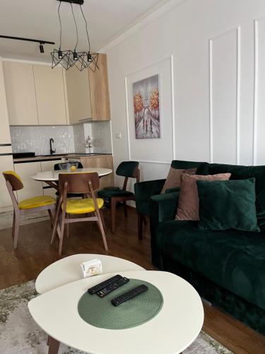 a living room with a green couch and a table at Apartman Natalijina Ramonda in Zlatibor