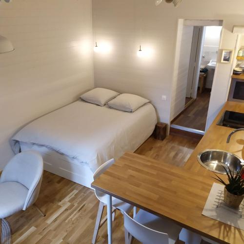 une petite chambre avec un lit et une table dans l'établissement STUDIO HORTENSIA à 2 pas du port - Confortable, classé 2 étoiles, à Cancale