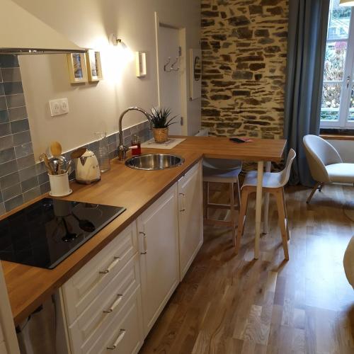 une cuisine avec un évier et un plan de travail en bois dans l'établissement STUDIO HORTENSIA à 2 pas du port - Confortable, classé 2 étoiles, à Cancale