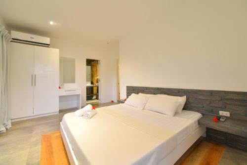 a bedroom with a large white bed and a kitchen at Diniview Villa Resort in Boracay