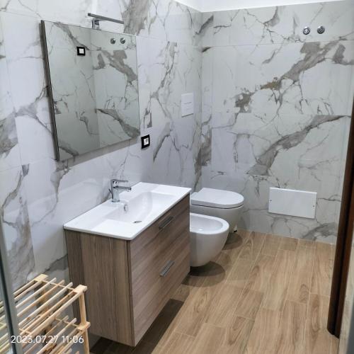 a bathroom with a sink and a toilet and a mirror at Bed and Breakfast Don Angelo Miramare in Realmonte