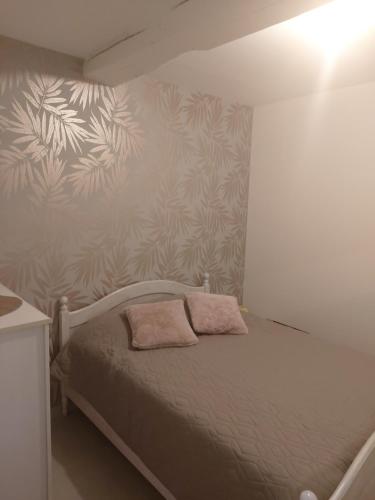 a bed with two pillows on it in a bedroom at Gîte Cabara in Cabara