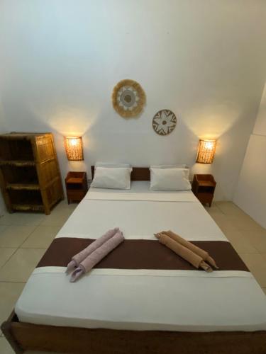 a bedroom with two beds and a clock on the wall at Salt Life Gili Trawangan in Gili Trawangan