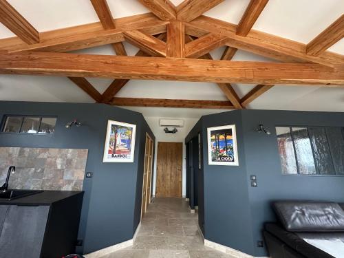 un couloir avec des murs bleus et un plafond en bois dans l'établissement Gîte Sainte Baume, à Plan dʼAups