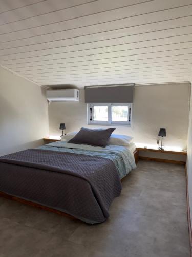 a bedroom with a large bed with two windows at Eretria Lofts in Eretria