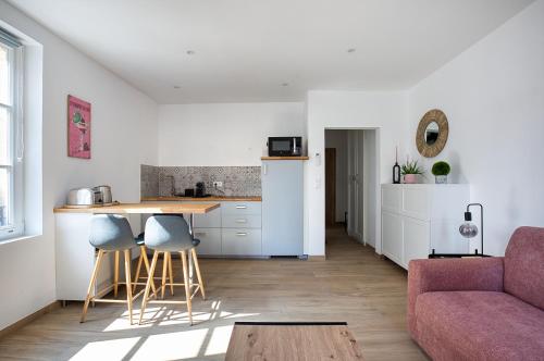 une cuisine et un salon avec un canapé et une table dans l'établissement Au coeur d'Obernai, à Obernai