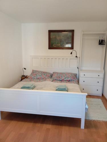 a bedroom with a white bed and a white dresser at Apartmán Kafíno in Nové Město na Moravě