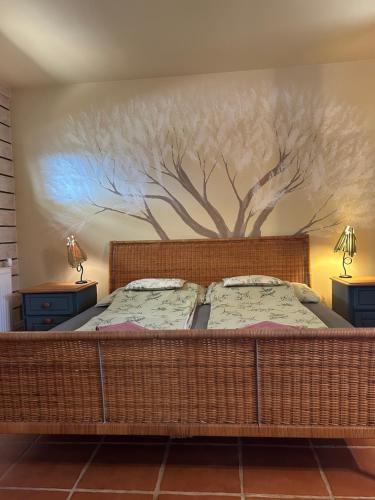 a bedroom with a bed with a tree mural on the wall at Lazy Days in Debrecen
