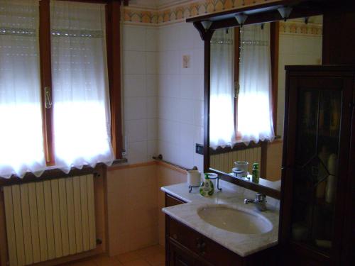 a bathroom with a sink and two windows at B&B Lattemiele in Fontanellato