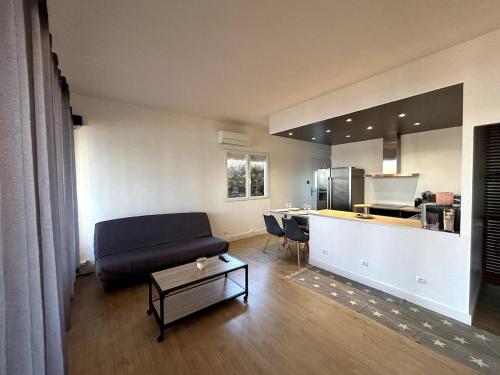 un salon avec un canapé et une cuisine dans l'établissement appartement climatisé au bord du lac marin, au Barcarès