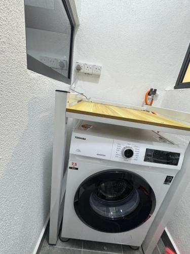 a washing machine in a room with a mirror at Cheras Trader Park By JR in Cheras