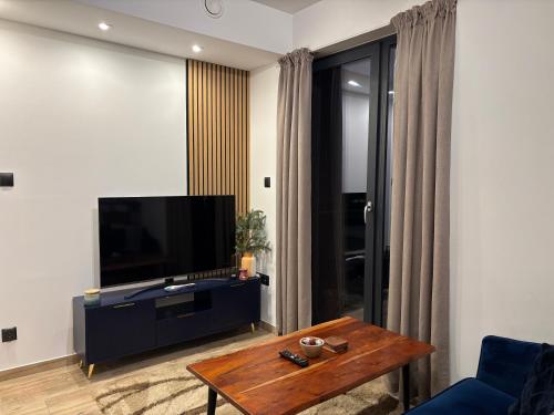 a living room with a tv and a coffee table at Przytulna kawalerka blisko centrum in Krosno