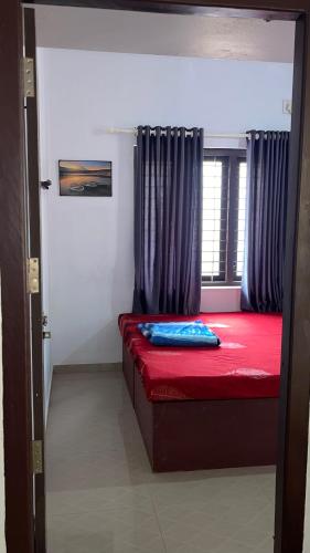 a bedroom with a red bed with a window at Scott legacy in Kulattūr