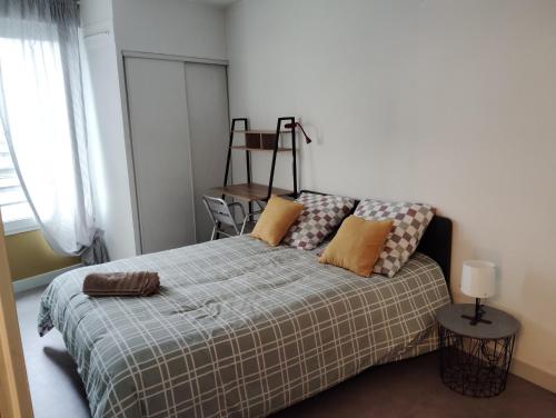 a bedroom with a bed with a blanket at Charmant appartement 2 chambres - Proche Tours in Joue-les-Tours