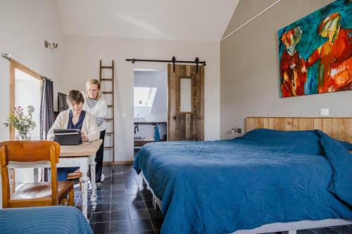 a man and a woman sitting at a table in a bedroom at B&B Art.14 in Morkhoven