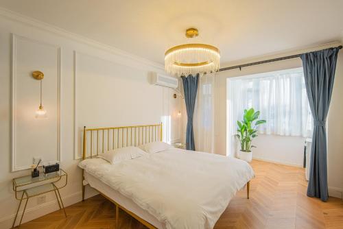a bedroom with a large white bed and a window at Tonight Homestay West Nanjing Road Shanghai in Shanghai