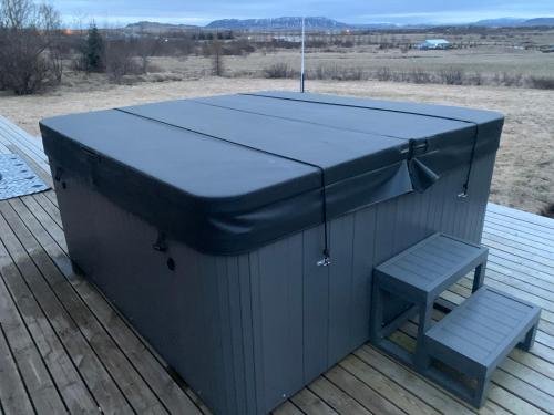 a hot tub and a bench on a deck at Ásabyggð 1 Flúðir in Fludir