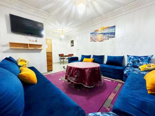 アガディールにあるLuxury Seafront Apartment in Agadir Vue Mer Taghazout Surf & Ocean View your Home placeの青いソファとテーブルのあるリビングルーム