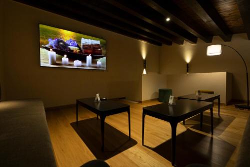 two tables in a room with a painting on the wall at Badiula in Carlentini