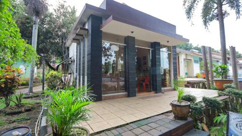 a house with a porch with plants in front of it at Lembah Gunung Kujang by ARBA in Gunungtua