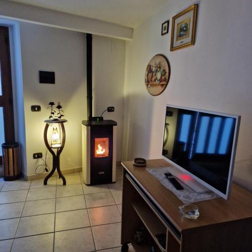 a living room with a television and a fireplace at A Casa di Nonna in Castelsaraceno