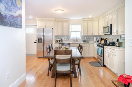 a kitchen with white cabinets and a table with chairs at 41 - 3BR Quincy - Lovely & Spacious Townhouse near Boston in Quincy