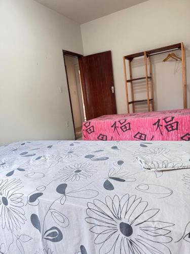 a bedroom with a bed with a blanket with flowers on it at Casa Clarice in Alto Caparao