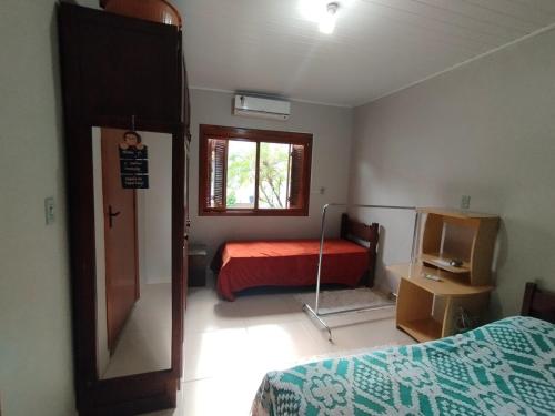 a bedroom with a bed and a mirror in it at Casa da Piscina in Rolante