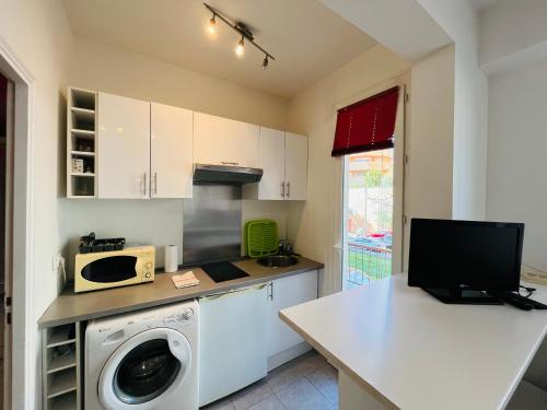 une cuisine avec un lave-linge et un micro-ondes dans l'établissement Grand studio de 30 m2 Promenade des Anglais, à Nice