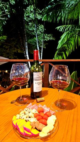 two glasses of wine and a plate of food on a table at Pousada Casa Dunas in Barreirinhas