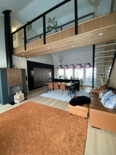 a living room with a couch and a dining room at Villa Ensola with pool in Savonlinna