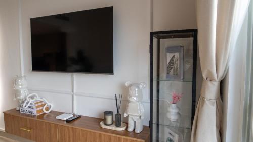 a living room with a television and a wooden shelf at Noor Homes - Luxury Approved by the Department of Culture and Tourism, Abu Dhabi in Yas Island in Abu Dhabi