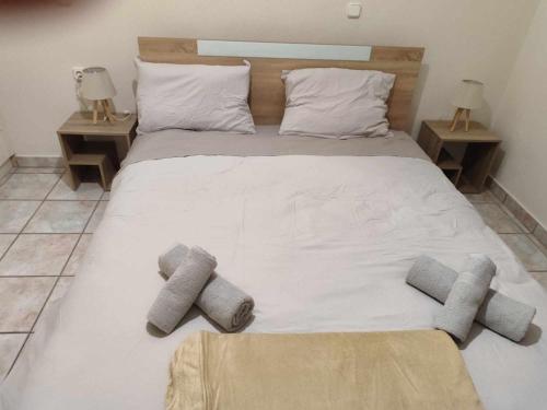 1 cama blanca grande con 3 almohadas en Cathrine's Apartment, en Tríkala