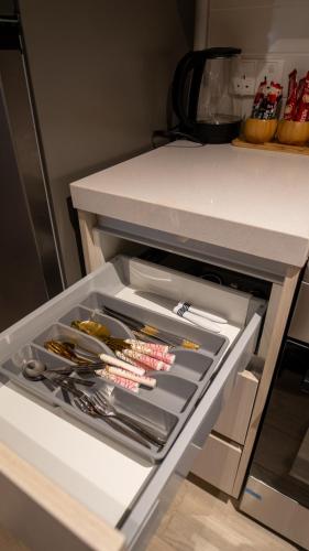 an open refrigerator drawer with lots of utensils at Noor Homes - Luxury Approved by the Department of Culture and Tourism, Abu Dhabi in Yas Island in Abu Dhabi