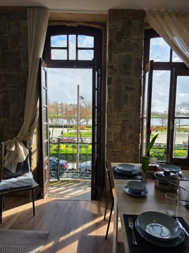 a dining room with a table and a large window at Margens do Rio in Vila do Conde