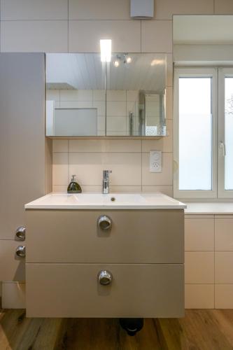 une cuisine blanche avec un évier et une fenêtre dans l'établissement Le 60-Appart'Hôtel-GregIMMO, à Vieux-Charmont