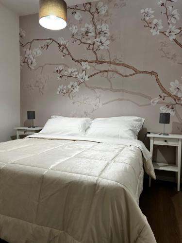 1 dormitorio con 1 cama blanca y un mural en la pared en Appartamento Gna Turidda, en Ragusa