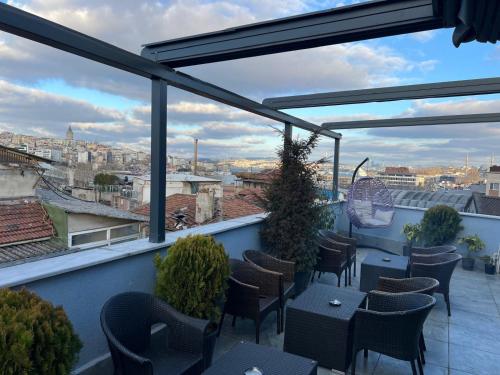 a balcony with tables and chairs and a view of a city at Hotel By Historia in Istanbul