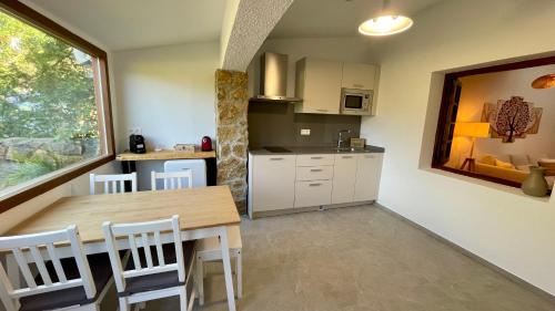 eine Küche und ein Esszimmer mit Tisch und Stühlen in der Unterkunft Troi Landetxea, Casa Rural Con encanto en el Goierri, Gipuzkoa, País Vasco in Mutiloa