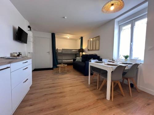 Il dispose d'une cuisine et d'un salon avec une table et un canapé. dans l'établissement T2 de Charme Rénové à Beg-Meil, À 250m de la Plage, à Fouesnant