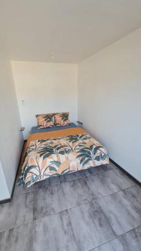 une chambre avec un lit dans une pièce blanche dans l'établissement Maison Proche Mer, à Pia