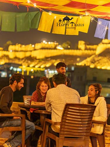 un grupo de personas sentadas en una mesa en un restaurante en Happy Trails Jaisalmer, en Jaisalmer