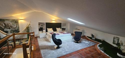 a bedroom with a bed and two black chairs at Apartamento Familia Azevedo in Esposende