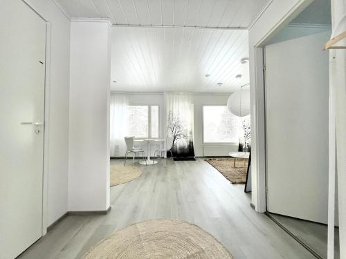 a living room with white walls and a table at Valoisa uusi kaksio keskellä Suomea in Haapavesi