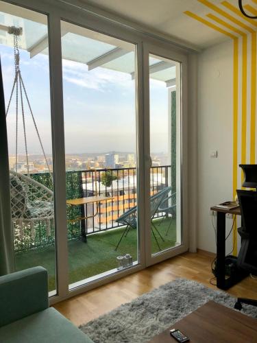 a living room with a large window with a view at City View Duplex - Stylish 2BR Apartment with parking in Skopje