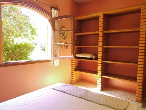 a bedroom with a bed and a window at Chácara Tâmo na mió, Confortável casa de campo para famílias com Wifi, max 15 pessoas in Limeira