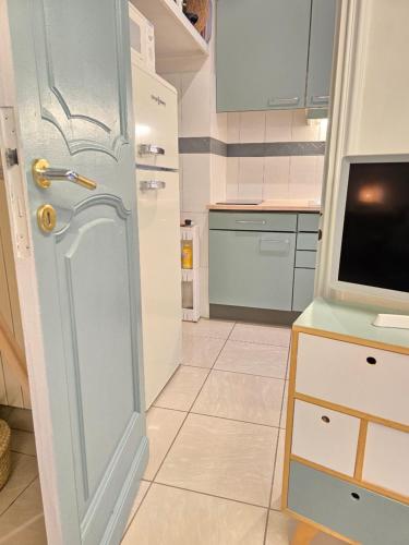 une petite cuisine avec une porte et une télévision dans l'établissement Studio devant la Mer, à Antibes